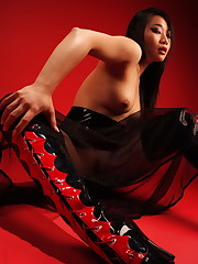 Busty asian kitten Yumi wearing heavy rubber and a dildo.